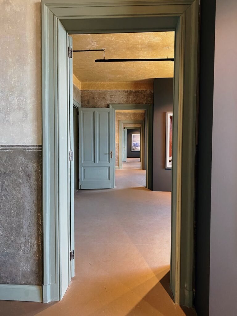 Financiera Alves Lucas en Jarama Portugalete A perspective view of a corridor featuring multiple open doors with subtle lighting.